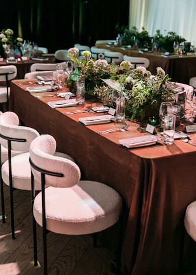 Inside the ballroom, 170 guests were seated for an elevated dining experience. The design direction played off the existing aesthetic of The Edition, incorporating caramel velvet linens, white boucle and black metal chairs, textured greenery, and reflective candlelight in infinity boxes.