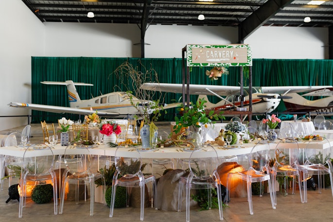 'Tap into travel,' Borunda advises of hosting inside an airplane hangar. 'Hosting an event at a hangar opens doors to many fun themes. Lean into the obvious aviation or travel themes, and decorate with planes and helicopters. Other fun themes can be ‘launch’ parties; milestones ‘reaching new heights’; or anything that can be a fun play on words in relation to planes, helicopters, or the hangar.'