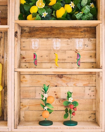 Other fruity accessories in the seasonal assortment: wine glasses, candleholders, ceramic fruit baskets, cocktail napkins, and dish towels with charming messages like “I love you berry much.”
