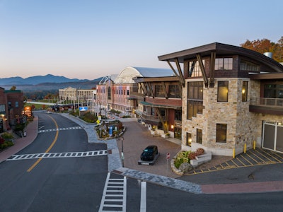 The Lake Placid Conference Center is pictured here in the foreground on the right. The light brown brick building in the middle is the façade of the 1932 Olympic ice arena. The large white curved dome is the 1980 Olympic arena.
