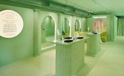 The Fancy Studs concept drew inspiration from the brand's color palette of mint, moss, and emerald tones. Clean lines and geometric precision dominated the design, while Doric-style columns, scalloped retail displays, and modern archways bridged the gap between traditional and modern aesthetics. Neon accents helped highlight and accentuate the architectural features. Studs co-founder Lisa Bubbers designed the pop-up in collaboration with Maya Elle Annotti of Familiar Stranger.