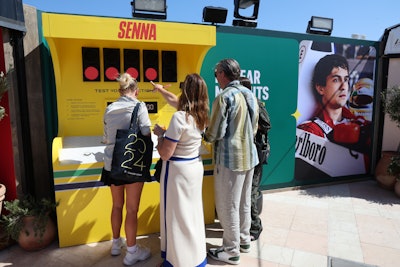 The Senna zone featured an interactive game based on F1 qualifying lap tournaments to test the reaction times of attendees. The space featured replica F1 track lights, a '90s-inspired pit wall, and vintage tires to further immerse guests.