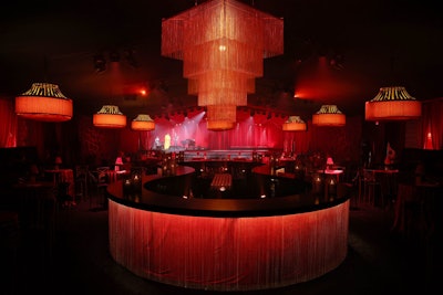Inside the theater, “We wanted to combine what you would expect at a classic cabaret environment—red, gold, fringe, and tassels—with a modern twist,” Williquette says. “We added seductive gold chain detailing throughout the ceiling and the environment, juxtaposing the classic and the modern. It was important to create an environment that allowed guests to enjoy a cabaret show, but also allowed them to mix and mingle like [people did at] the speakeasies of the Roaring ’20s as well.”