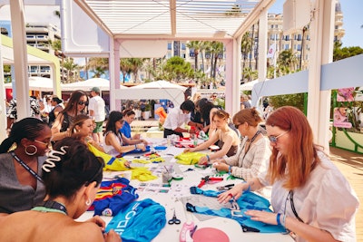 Highlights included a charm bar, where visitors could create unique accessories and jewelry from an assortment of new and thrifted materials, beads, charms, and chains with BONBONWHIMS. In another area, artist Sophie Hird collaborated with attendees to create custom bags, constructed entirely out of repurposed materials like football jerseys and sports paraphernalia. Other creation stations included creating marble-dipped accessories with London Sneaker School.