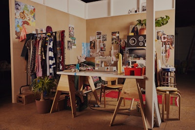 The DIY Den, curated by the artist Kai, was equipped with a sewing machine, bolts of fabric, and ripped-out magazine pages on the wall. The staging was based on three Pinterest trends: dorm room props, cozy earthy living room, and mirror mosaic art ideas. Kai led a garment-making activation in the room.