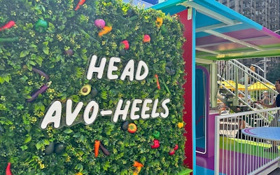 A green wall is dotted with colorful veggies.