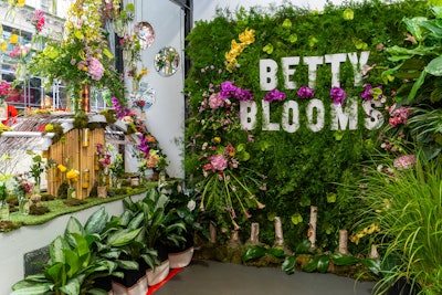 Inside the pop-up, the decor includes a lush flower wall with the Betty Blooms logo. A window installation features bottles and cans from Lively’s beverage brands.