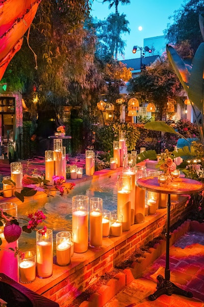 'We leaned heavily into natural terrazzo, marble, stone, clay, and scalloped wood, all accented with lime-wash finishes; dreamy candlelight; and lush, loose greens and florals dotted alongside potted herbs,' Mazzuca says. Mallory with the Flowers provided florals while Vogue Candles provided candles.
