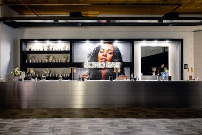 The pop-up event featured a hotel-theme setup with a custom check-in process, product education at the Bond Bar, styling sessions in the Styling Lounge, complimentary beverages, photo moments, and product giveaways.