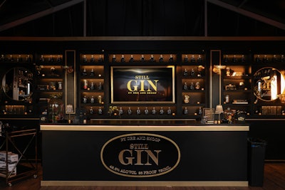 Inside, the speakeasy featured a full bar, tables, and shelves lined with hip-hop memorabilia, books, and black and gold bottles of Still G.I.N. By Dre and Snoop. Soursop Flower Farm provided florals for the activation.