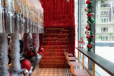 Another photo backdrop features a festive replica of the “All I Want for Christmas Is You” sheet music.
