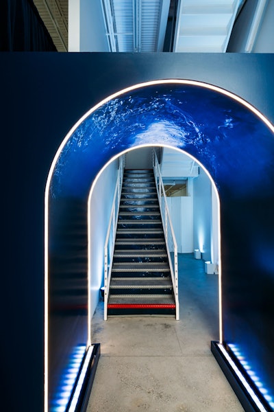Attendees were welcomed by an illuminated tunnel simulating waves and water movement, and the stairs leading to the main event space were detailed with a vinyl water print.