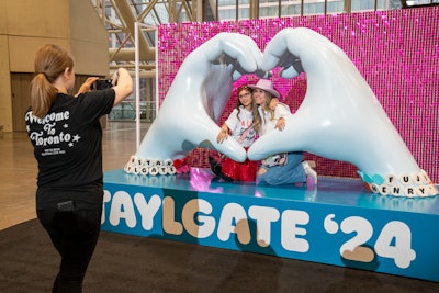 Guests pose inside an 8-foot-tall heart hands photo activation sponsored by Fujifilm.