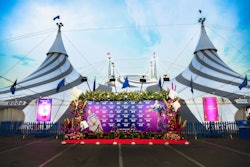 At check-in, guests were welcomed and guided to one of two media walls, each draped in luxurious dark cyan velvet and adorned with vibrant, show-inspired florals.