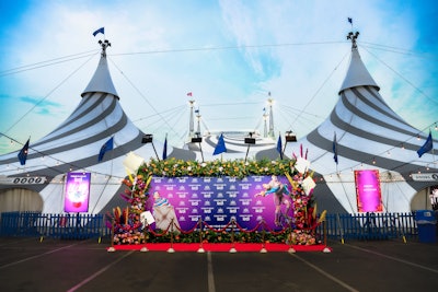 At check-in, guests were welcomed and guided to one of two media walls, each draped in luxurious dark cyan velvet and adorned with vibrant, show-inspired florals.