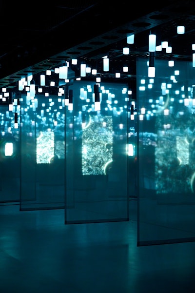 Panels with colorful designs and geometric light fixtures hang from the ceiling.