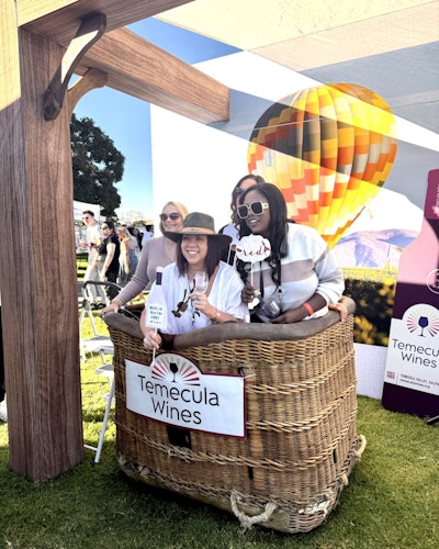 Festivalgoers posed in a hot air balloon basket as part of the Temecula Valley Wine Country activation.