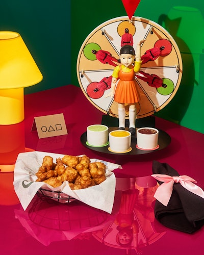 The Red Bite, Green Bite appetizer puts a playful spin on the Red Light, Green Light game in Squid Game. Diners spin the wheel to determine which dipping sauce to dunk their crispy chicken bite into, with each ranging in heat level from mild to extra spicy.