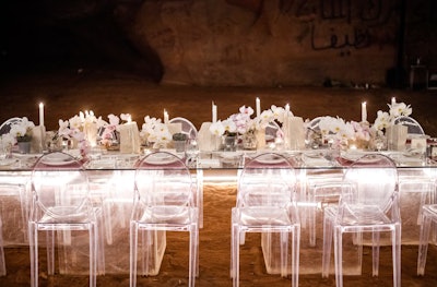 The illuminated steel structure measured almost 15 feet wide, 20 feet long, and 8 feet high, with a transparent table set for 14 in the center. LED lights strung along the frame lit the space for the evening. See more: See How This Designer Threw a Dinner Party in the Desert