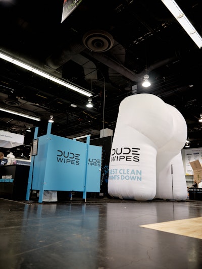 Attendees were invited to visit the 'DUDE Wipes Dump Club' booth featuring a giant inflatable butt, a 'mini pooper' (aka a Mini Cooper), and a bathroom stall with free giveaways.
