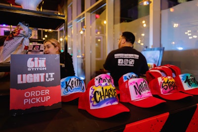 The 6ix Stitch merch station offered personalized hats and bandannas with custom Toronto patches and live airbrushing.