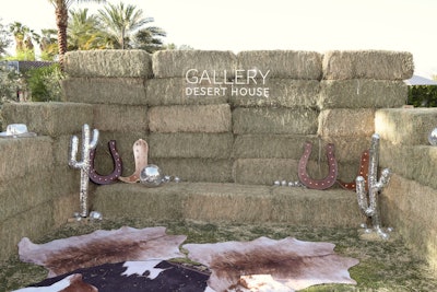 Lifestyle publisher Gallery Media Group hosted Gallery Desert House, an immersive celebration of music, culture, fashion, and beauty. The space featured a photo op made from hay bales, cactuses, and horseshoes.