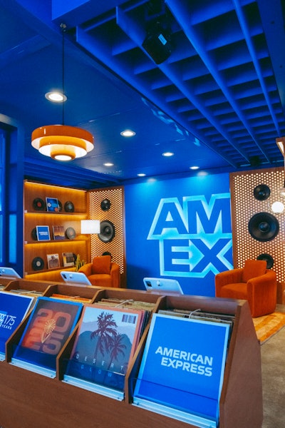 The Amex Experience was a creative space where card members and up to three of their guests could celebrate their love for music and the culture that surrounds it. The nostalgia-inducing space leaned into classic records, and featured an interactive photo booth with a selection of album cover filters, a retro fridge filled with Coca-Cola, a classic dart game, and more.