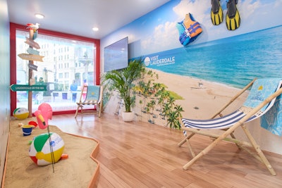 Inside, guests found themselves immersed in a South Florida-inspired retreat, complete with coastal decor, beach chairs, palm trees, and surfboards—capturing the essence of Greater Fort Lauderdale’s endless summer. Lifeguard-clad brand ambassadors were on hand to engage visitors with travel inspiration while handing out exclusive giveaways including sunglasses, surfboard-shaped mint containers, and bottles of tropical punch.