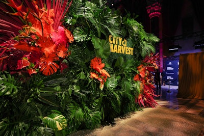 The step-and-repeat included a lush photo backdrop with green foliage and pops of color.