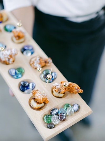 A '90s-themed corporate event—held in 2023 in San Francisco and produced by Glow Events—featured these nostalgic Mancala board passed trays, created by Foxtail Catering. See more: This Corporate Event Has All the '90s Decor Inspo You Need