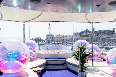 The design blended modern nautical style featuring iridescent vinyls and giant balls, plus striped uniforms, refined florals, and framed light LED tubes for the DJ booth. A standout moment was a crowd-favorite ball pit, which doubled as a social-ready backdrop.