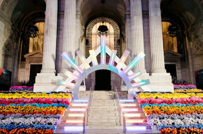 The 10th annual Knot Gala, which took place in 2019 at the New York Public Library, featured the theme of “Shine Bright” and was planned and designed by Jove Meyer Events. Guests were greeted by a rainbow floral installation and an illuminated sunburst entryway.