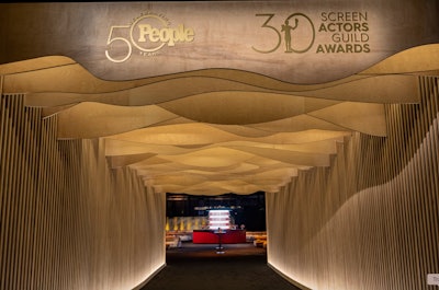 February 2024 marked People magazine's 26th year hosting the after-party for the Screen Actors Guild Awards. The event was designed and produced by Event Eleven with an undulating ceiling entry made from naw natural wood. The team carried the undulating shapes and raw natural wood throughout the event space, giving the walls a canvas for lighting from Images by Lighting to play with shadows.