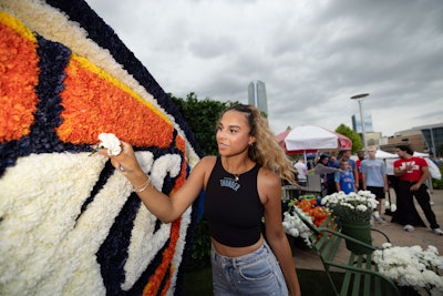 Fans played a hands-on role in completing the installation, adding blooms to their team’s logo—a playful and heartfelt nod to the phrase, 'give their team their flowers.'