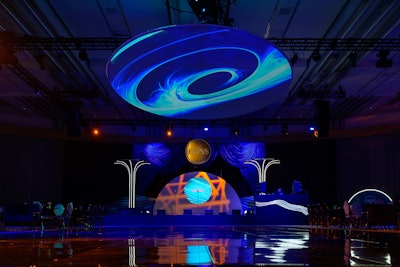 For the after-party, AKJOHNSTON's design drew inspiration from organic motion. To evoke the feeling of an arena, the team anchored each end of the ballroom with custom goal-inspired structures framed in deep blue velvet drape and sleek metallic finishes. Flanking each stage were 12-foot neon radial light sculptures, designed and fabricated in-house, that added height and color and served as stylized 'goal posts.'