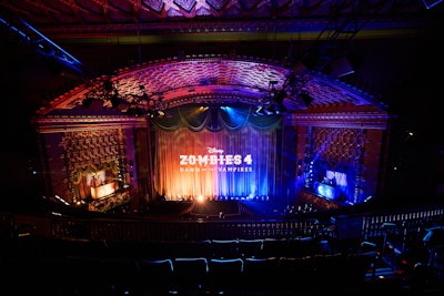 Inside the El Capitan Theatre, guests picked up popcorn, drinks, and light-up wristbands that revealed their assigned faction, Daywalker or Vampire. Photo ops allowed attendees to step into the film’s key art and view costumes from the movie. Two dueling DJs, each representing a faction, kept the energy high as the wristbands lit up in sync with the music. Before the screening, Ayo Davis, president of Disney Branded Television, introduced a custom version of the theater’s Crystal Curtain Light Show, reimagined with Zombies 4 elements.