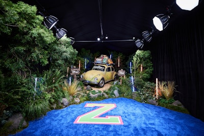 Guests entered through a glowing forest-scape featuring the film’s signature VW bug, which serves as the vehicle that brings the original characters into their summer camp adventures. Orange and blue LED-lit trees hinted at the new elemental powers in the film.